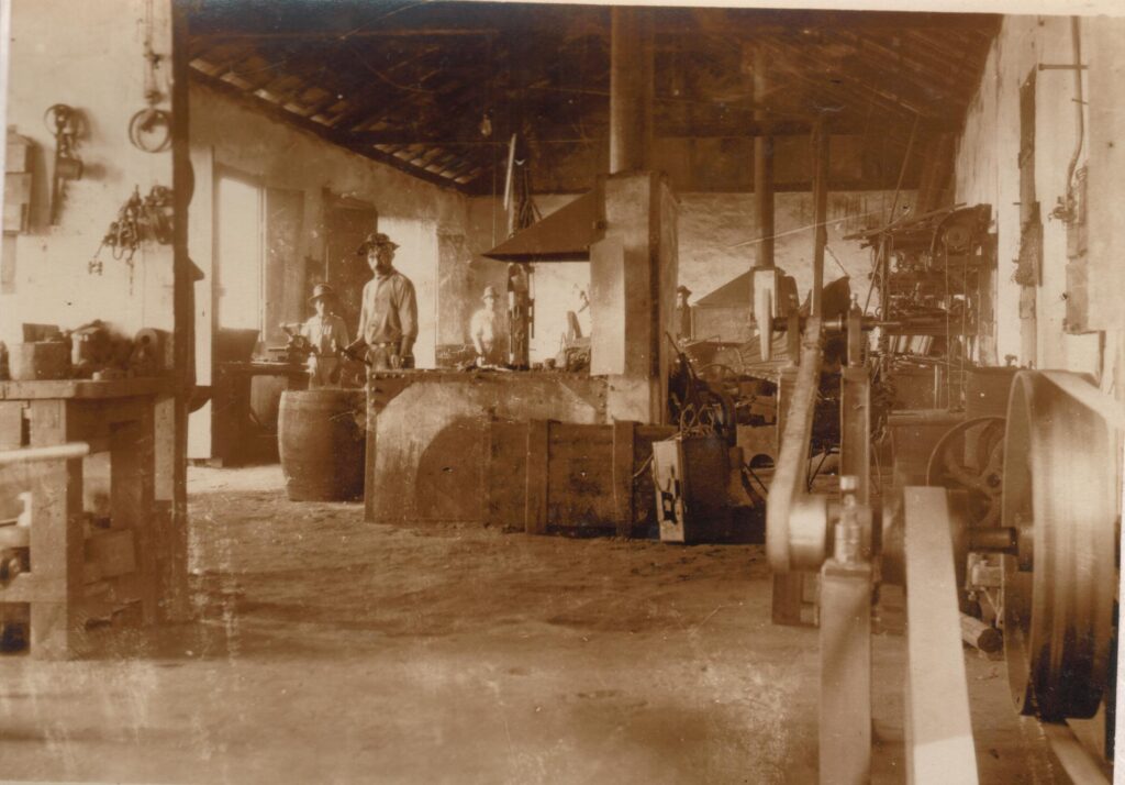 Trabalhadores no galpão de criação de ferramentas de ferro da Usina Wigg. Foto de 1911, autoria desconhecida